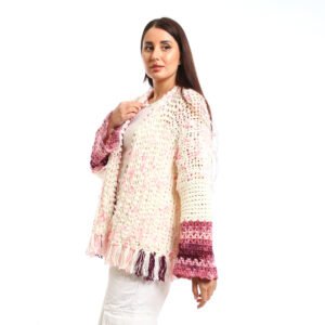 Handmade-looking crocheted open cardigan.is primarily cream-colored with pink featuring wide sleeves with color-blocked bands near the cuffs.